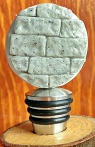 Polymer clay, stone work etched into it on a stainless bottle stopper.