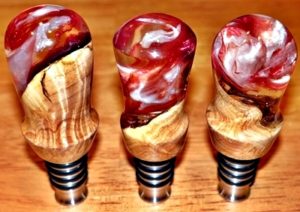 three turned bottle stoppers with resin
