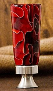 red ribbons in resin on beer bottle opener