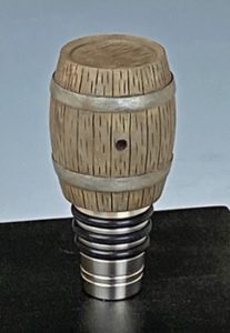 hand carved whiskey barrel on a bottle stopper