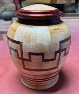 Wood segmented urn, with a bronze threaded ring for the threads.